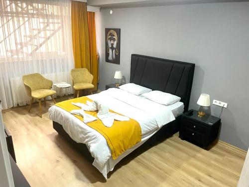 1 dormitorio con 1 cama con manta amarilla y 2 sillas en BY KARAM OTELCİLİK, en Estambul