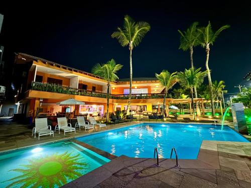 a hotel with a swimming pool at night at Luna Hotel Boutique - Beira Mar in Guarujá