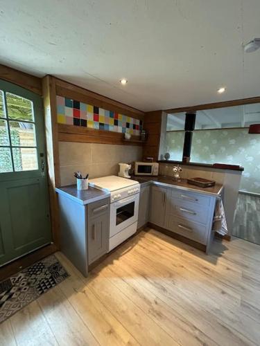 a kitchen with a stove and a sink in it at Gîte - Saint-Ellier-Du-Maine in Saint-Ellier-du-Maine