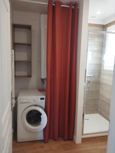 La salle de bains est pourvue d'un lave-linge et d'un rideau de douche rouge. dans l'établissement Valras plage, sérignan maison à 400m de la plage, à Sérignan