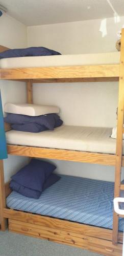 - un lit superposé en bois avec des oreillers sur l'étagère du bas dans l'établissement Résidence Thabor D - THABOR D - THAD130 MAE-4228, à Modane