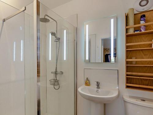 a white bathroom with a shower and a sink at 1 bed property in Beaminster 75192 in Mosterton