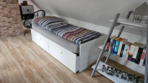 a bunk bed in a room with a book shelf at Loft- Privatzimmer 30qm im Dachgeschoss mit eigenem Bad in Ahaus