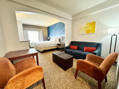 a living room with a couch and a bed at Comfort Suites East Brunswick - South River in East Brunswick