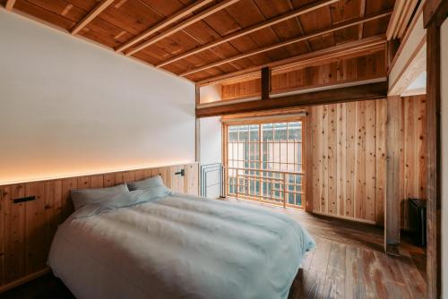 a bedroom with a bed and a large window at Ikeda Ryokan - Vacation STAY 79298v in Nishinoomote
