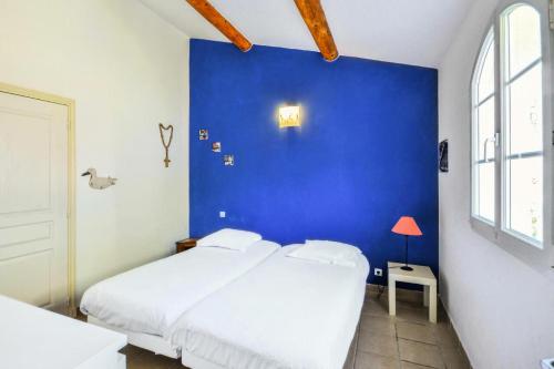 - une chambre bleue avec un lit et un mur bleu dans l'établissement Les Mas et Villas de Pont Royal en Provence - maeva Home - Maison 5 pièces 10 personnes avec piscine privée - Prestige - Super Home MAE-6064, à Mallemort