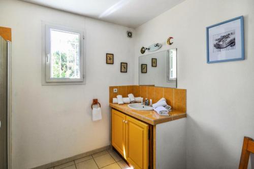 La salle de bains est pourvue d'un lavabo jaune et d'une fenêtre. dans l'établissement Les Mas et Villas de Pont Royal en Provence - maeva Home - Maison 5 pièces 10 personnes avec piscine privée - Prestige - Super Home MAE-6064, à Mallemort