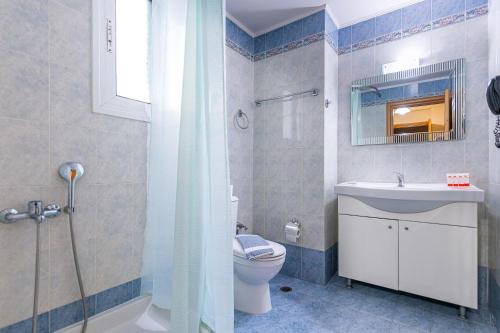 La salle de bains est pourvue d'un lavabo, de toilettes et d'un miroir. dans l'établissement Faros II, au Pirée