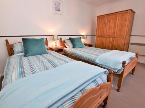 een slaapkamer met 2 bedden en 2 nachtkastjes bij 3 Bed in St Day 37014 in Saint Day