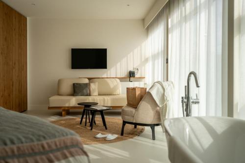 un soggiorno con divano e sedia di Noordzee, Hotel & Spa a Cadzand-Bad