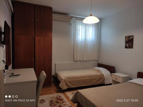 a bedroom with two beds and a desk and a dresser at Eleni's Rooms in Ioannina