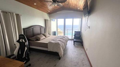 a bedroom with a bed and a large window at Casa Flomingo Roatan in West Bay