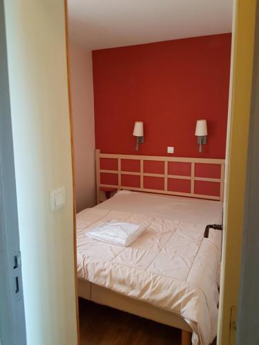 - une chambre dotée d'un lit avec un mur rouge dans l'établissement Cap Esterel, à Saint-Raphaël