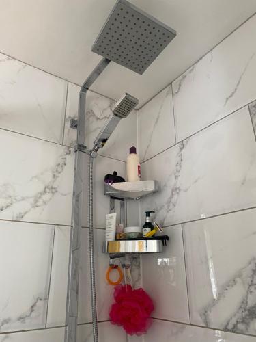 a shower in a bathroom with white marble walls at Rooms in Hadleigh,Essex in Hadleigh