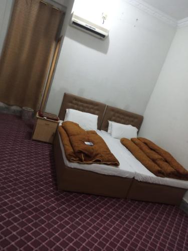 ein Schlafzimmer mit einem Bett mit braunen Decken darauf in der Unterkunft Swat Inn Hotel in Mingora