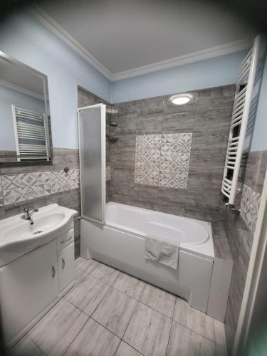 a bathroom with a white tub and a sink at Apartamenty Olimpijska in Gorzów Wielkopolski