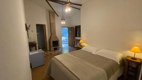 sypialnia z łóżkiem i pokój z kominkiem w obiekcie Pousada Caminhos de Gaia w mieście São José dos Campos