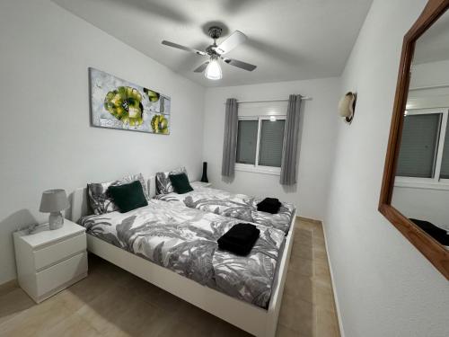 um quarto com uma cama e uma ventoinha de tecto em Apartamento Agua Rosa em Torrevieja