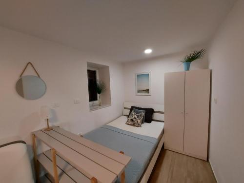 a small bedroom with a bed and a cabinet at Casa Orange in Koper