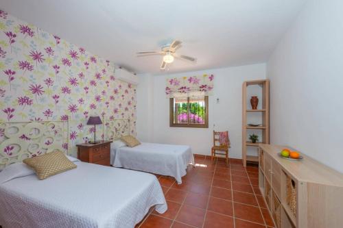 1 Schlafzimmer mit 2 Betten und einem Deckenventilator in der Unterkunft Villa Franmarco by Villa Plus in Nerja