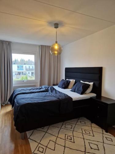 a bedroom with a large bed in a room with a window at Radhus nära sjö, Arlanda och Stockholm in Upplands-Väsby