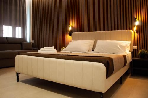 a large white bed in a room with a couch at Sicily Luxury Rooms in Palermo