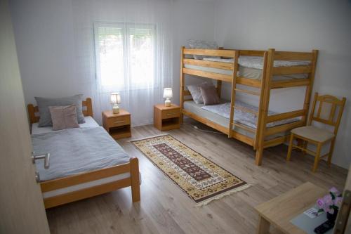 a bedroom with two bunk beds and a chair at Apartment Garden in Blagaj