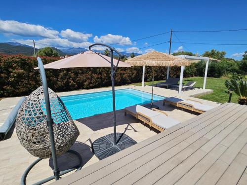 a chair and an umbrella next to a swimming pool at Chambre d'hôtes Corse Villa Moorea chez l'habitant in Ventiseri