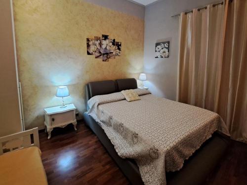 um quarto com uma cama e uma mesa com um candeeiro em Centro Storico Suites Giovinazzo em Giovinazzo