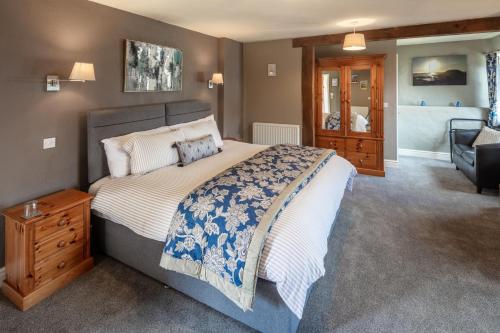a bedroom with a large bed and a chair at East Hook Farmhouse in Haverfordwest