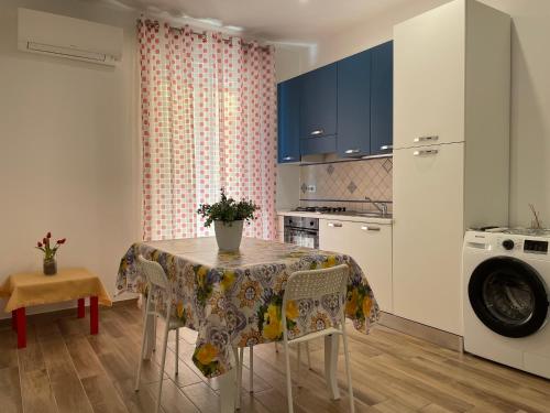 eine Küche mit einem Tisch und einer Waschmaschine in der Unterkunft Suite de la Sicilienne in Castellammare del Golfo