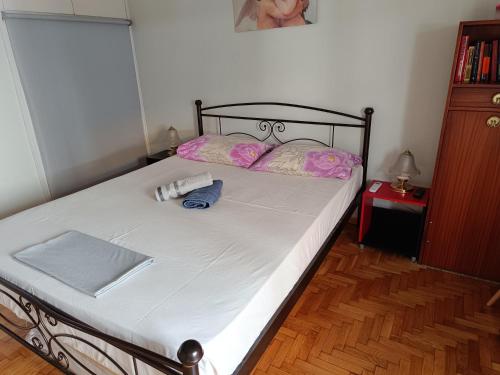 1 dormitorio con 1 cama con almohadas rosas en Acropolis within 10min. walk!, en Atenas