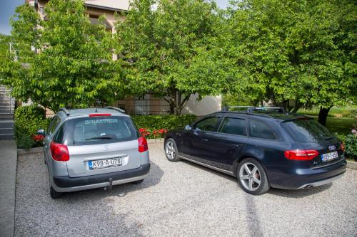 two cars parked next to each other in a driveway at Apartment Garden in Blagaj