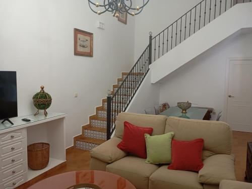 サンルーカル・デ・バラメダにあるLas Nievesのリビングルーム(赤と緑の枕が付いたソファ付)
