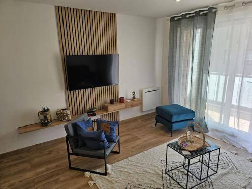 a living room with two chairs and a flat screen tv at Le St Antoine - Centre Ville - Parking in Belfort