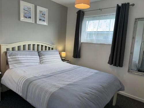 a bedroom with a large white bed with a window at 62 M&T Chalets , 2 bed detached chalet Florida holiday park Hemsby in Hemsby