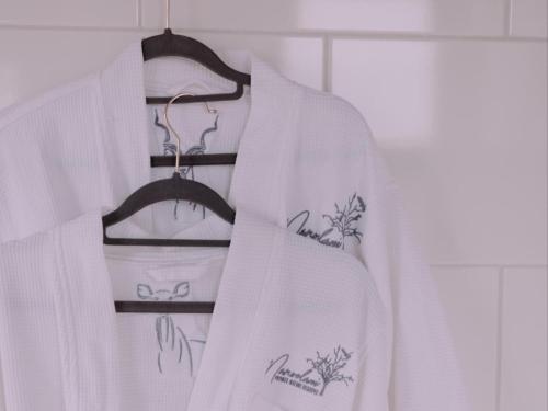 a white robe is hanging on a rack at Maroelani Lodge- Greater Kruger Private Reserve in Hoedspruit