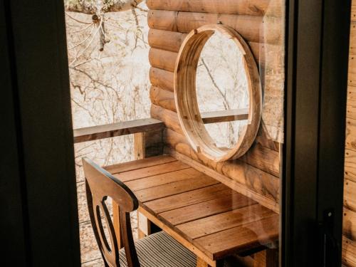 a mirror and a wooden table and chair on a balcony at Maroelani Lodge- Greater Kruger Private Reserve in Hoedspruit