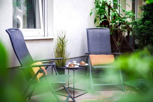 two chairs and a table with a plate of food at One bed apartment at central location in Budapest in Budapest