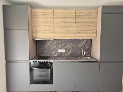 a kitchen with stainless steel appliances and wooden cabinets at 5 Dragos Suites in La Orotava