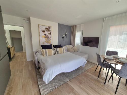 a bedroom with a white bed and a living room at 5 Dragos Suites in La Orotava