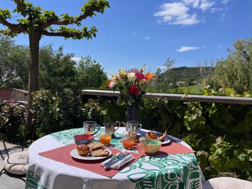 a table with a plate of food and oranges on it at Gîte de charme 5 étoiles pour couple avec sauna et jacuzzi extérieurs privatifs in Peaugres
