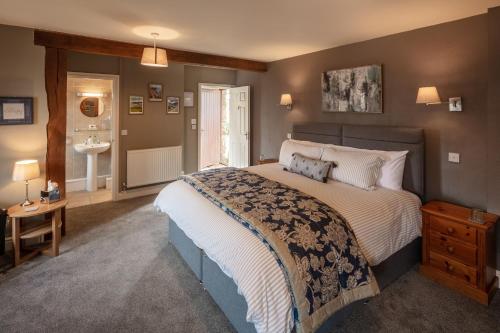 a bedroom with a large bed and a bathroom at East Hook Farmhouse in Haverfordwest