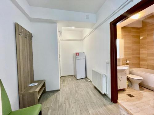a bathroom with a toilet and a sink and a refrigerator at Catalina Summerland Apartaments Mamaia Nord in Mamaia