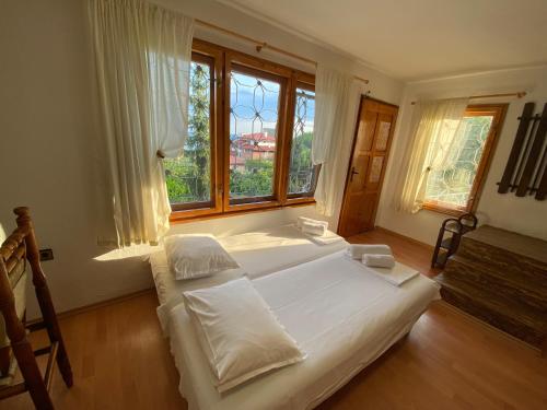 a bedroom with a large white bed and a window at Villa Stella - private house with parking spot, pool and sea view in Varna City
