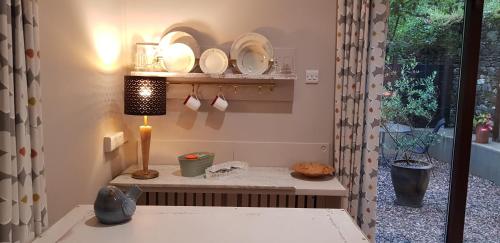 um quarto com uma mesa com placas e um candeeiro em Pink Granite Garden of Ireland em Tinahely