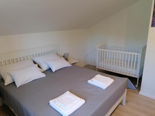 Un dormitorio con una cama con dos almohadas y una cuna. en Apartman Vrh, en Matulji