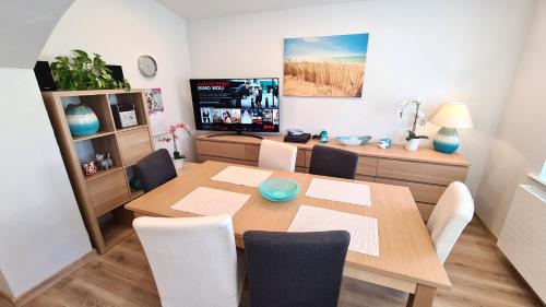 uma sala de jantar com uma mesa de madeira e cadeiras em Apartament Fredry em Świnoujście