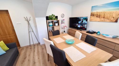 uma sala de jantar com uma mesa e uma televisão em Apartament Fredry em Świnoujście