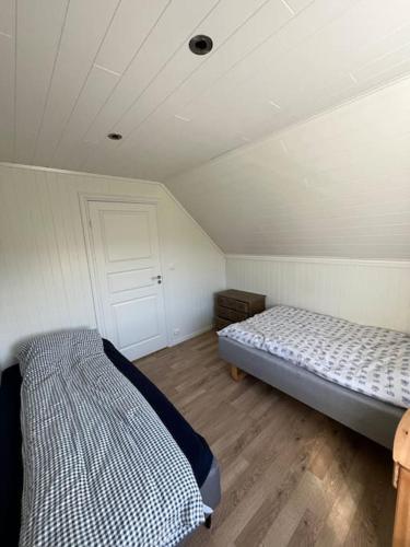 a bedroom with two beds in a room at Feriehus og naust i idylliske omstendigheter in Tjørvåg